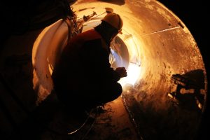 employee crouching in a dark tunnel